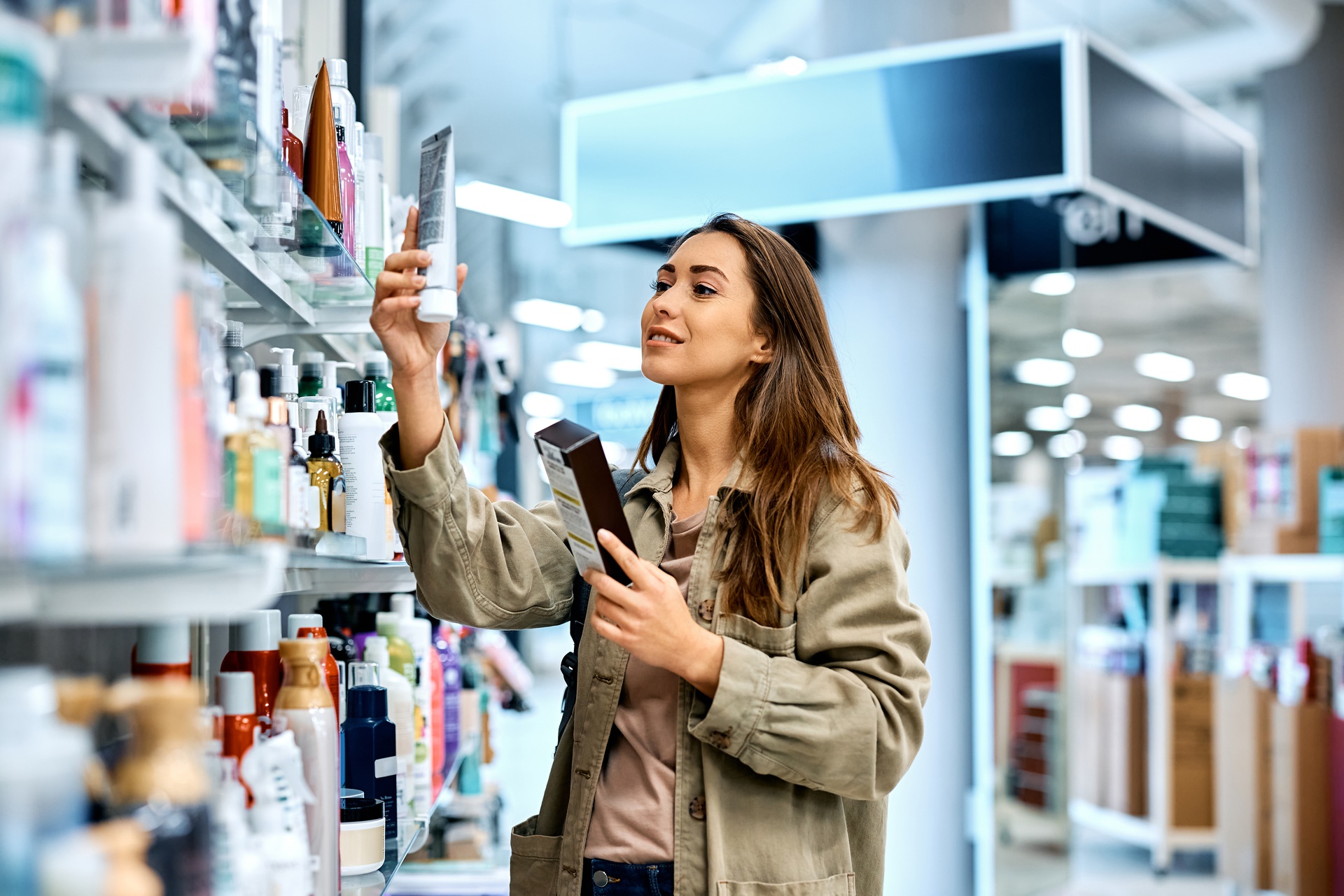 Woman shopping for cosmetics and examining the labels.